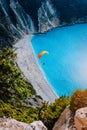Figure of a parachutist skydiver with orange parachute against a blue lagoon of Myrtos Beach, Kefalonia Island, Greece Royalty Free Stock Photo