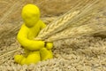 Figure plasticine man sits among the wheat and keeps holding ear Royalty Free Stock Photo