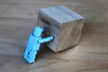 Figure pushing a wooden cube