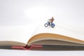 figure rides on a motorcycle over open diary book. Travel concept