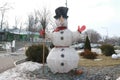 A figure of a snowman with a broom in the yard