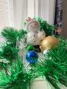 The figure of a snowman on a white table, a book in the background. Christmas decorations. New Year Royalty Free Stock Photo