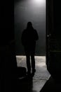 Back view of a silhouette of a man in a dark corridor Royalty Free Stock Photo