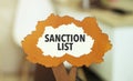 figure of a tree with text sanction list inside the foliage. Business concept financial tables with a pen