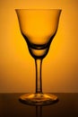 Figured wine glass for sherry on a background of orange spotlight Royalty Free Stock Photo