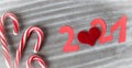 Figures of the coming New year - 2021 - cut out of paper , with a festive caramel and a heart on a gray background, top view, Royalty Free Stock Photo