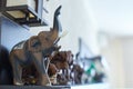 Figures of elephants on shelf. Wooden, stone and ceramic exhibits of collection, happiness and luck at home.