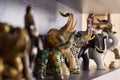 Figures of elephants on shelf. Wooden, stone and ceramic exhibits of collection, happiness and luck at home.