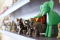 Figures of elephants on shelf. Wooden, stone and ceramic exhibits of collection, happiness and luck at home.