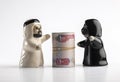 Figures of an Emirati couple embracing money