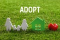 Figures of family, red heart and house on grass. Child adoption concept Royalty Free Stock Photo