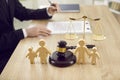 Figures of family are separated by judge's gavel, which symbolizes divorce case and custody of child