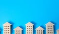 Figures of houses on a blue background. Concept of searching for options in real estate market. Search for housing. Realtor