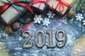 Figures 2019. New year of the pig. Festive Christmas composition with gifts, boxes, cones, walnuts, red flowers poinsettia on a wo Royalty Free Stock Photo