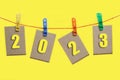 Figures for 2023 are posted on clothespins, on clothesline, on white background Royalty Free Stock Photo