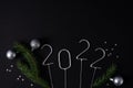 Figures for the upcoming new year 2022 with fir ropes and silver Christmas balls