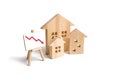 Figures Wooden houses and red arrow down. The concept of falling prices and demand for real estate, crisis and recession Royalty Free Stock Photo