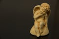 A figurine of an angel of a child with wings of yellow clay on a Royalty Free Stock Photo