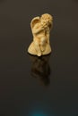 A figurine of an angel of a child with wings of yellow clay on a Royalty Free Stock Photo