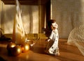 figurine of an angel, golden Christmas balls, pyramid candle on a textile background