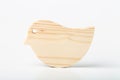 A figurine of a bird carved from solid pine by a hand jigsaw. On a white background