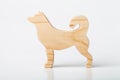 A figurine of a dog, a husky, carved from a solid pine tree by a hand jigsaw. On a white background