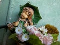 Figurine of a girl with flowers in a web and dust