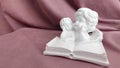 Figurine of little angels reading a large book close-up Royalty Free Stock Photo