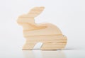 A figurine of a rabbit or a hare carved from solid pine by a hand jigsaw. On a white background