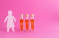 Figurine of a woman made of wood with bottles of alcohol on a pink background. Female alcoholism treatment concept, copy