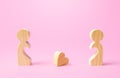 Figurines of people separated from each other and a lost heart. Breakup, end of love. Relationship problems of the couple