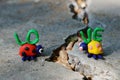 Figurines of two ladybirds made of plasticine. The figures are placed opposite each other. There`s a crack between them. Next to