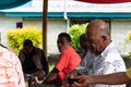 Fijan man handing coconut bowl of traditional Kava to another ma