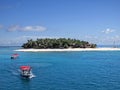 Fiji island best beach photo. Island with forest and cottage, natural panorama with boats with red roofs.