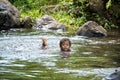 Fijian boy swimming in natural pond at rainforest