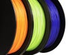 Filament for 3d printing. Bright termoplastic of neon orange, green and blue colors. Isolated on white background.