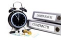 File folders and alarm clock symbolize time pressure while working on contracts and insurance Royalty Free Stock Photo