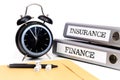 File folders and alarm clock symbolize time pressure while working on finance and insurance Royalty Free Stock Photo