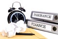 File folders and alarm clock symbolize time pressure while working on finance and insurance Royalty Free Stock Photo