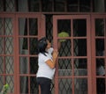 Filipina Maid Cleaning Window