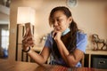 Filipina nurse using smartphone at home