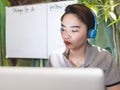 A filipina woman in work uniform but at home engaged at transcribing, listening to audio on her headset Royalty Free Stock Photo