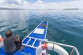 A Filipino boatman rests near the bow of a tourist bangka or outrigger cruising through calm glassy waters in Bohol, Philippines