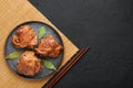 Filipino Chicken Adobo on dark gray plate on black slate backdrop. Filipino food. Braised chicken thighs