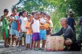 Filipino children standing in a line and holding snack in their