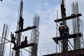 Filipino construction steel-men working joining column steel pieces on board scaffolding pipes on high-rise building