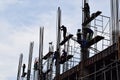 Filipino construction steel-men working joining column steel pieces on board scaffolding pipes on high-rise building