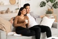 Filipino couple resting at home and watching tv