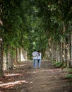 Filipino couple walking at the center of a tree pathway