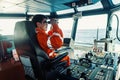 Filipino deck Officer on bridge of vessel or ship looking through binoculars